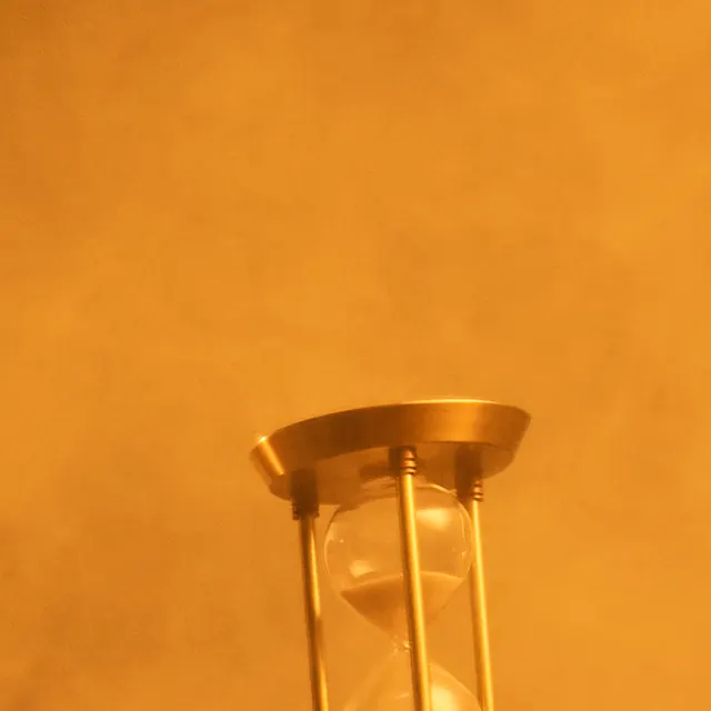 The golden hourglass held up in the smoke.